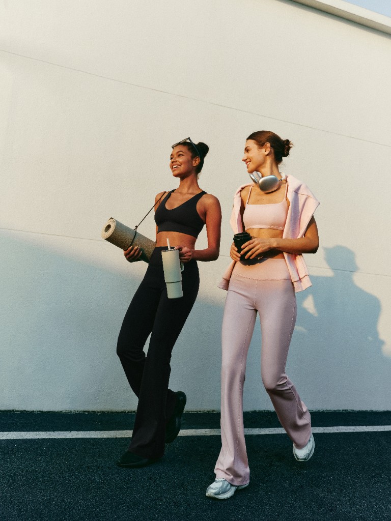 Two friends in SilkContour activewear walking together with coffee